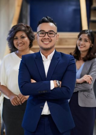 Leadership Confident happy young entrepreneur and his colleagues behind